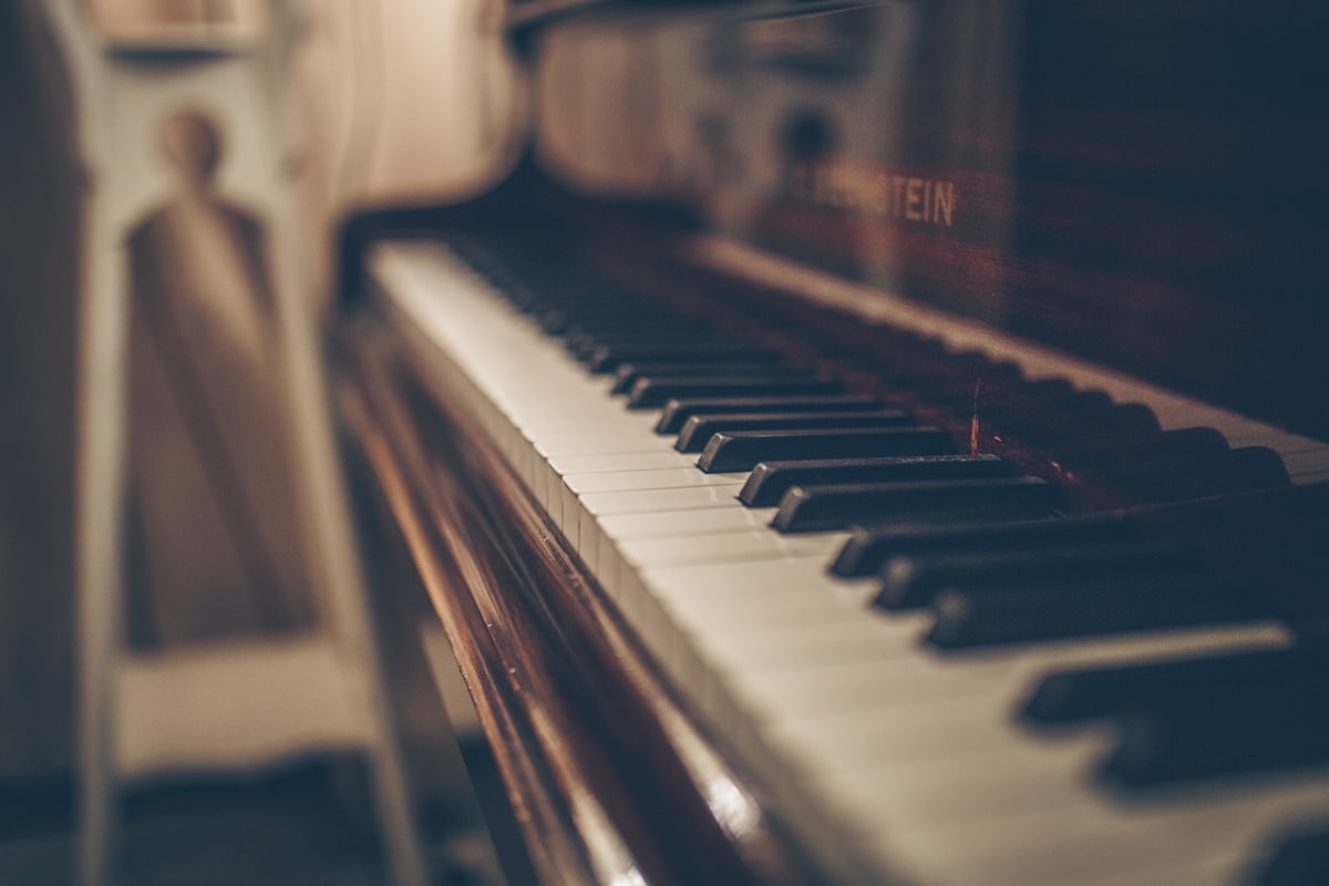 Close-up of a warm-toned grand piano's keys in soft cinematic light